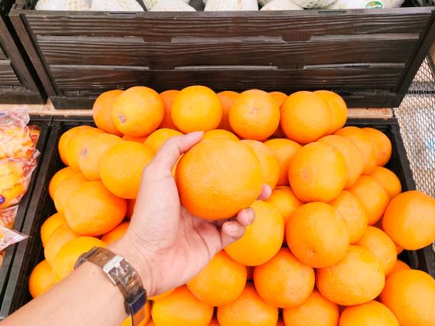 istock Asian Man Hand holding orange orange fruit 2168303327