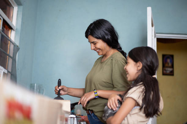 istock Mexican mother and daughter in modest kitchen, cooking 2168307311