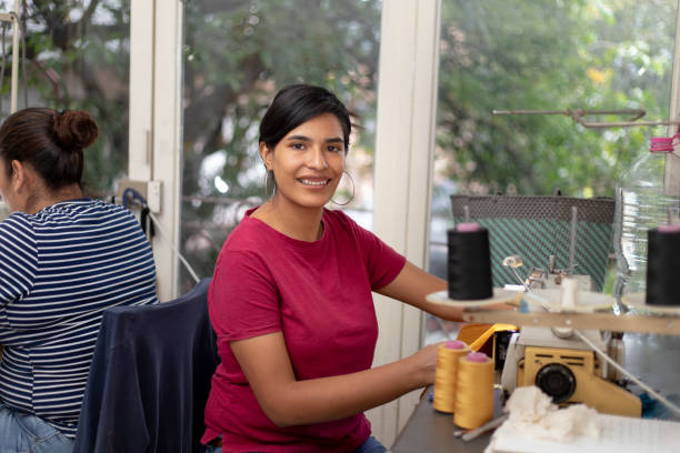 istock Hispanic Woman working at sewing workshop on industrial sewing machine 2168308508