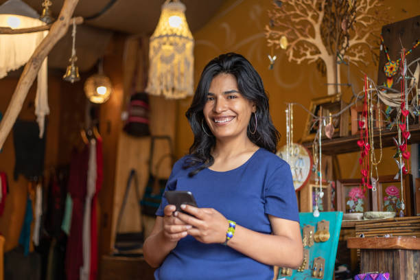 istock woman using smartphone while working or shopping at clothing store boutique 2168308735