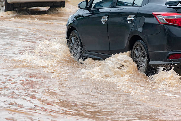 istock Car wheel in muddy rain and floodwater 2168309273