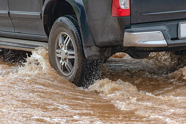 istock Car wheel in muddy rain and floodwater 2168309297