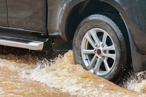 istock Car wheel in muddy rain and floodwater 2168309299
