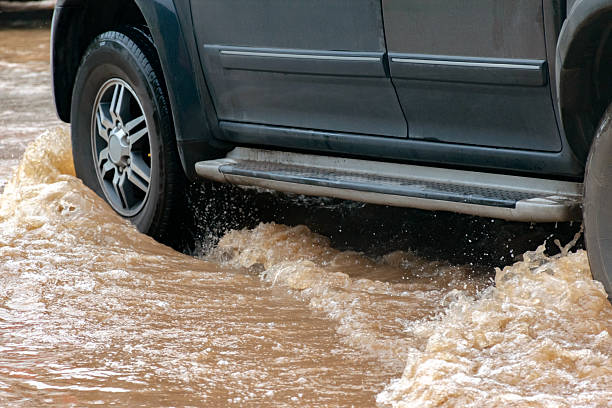 istock Car wheel in muddy rain and floodwater 2168309306