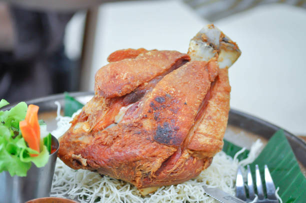 Woman hand holding a metal bowl of  braised trotter