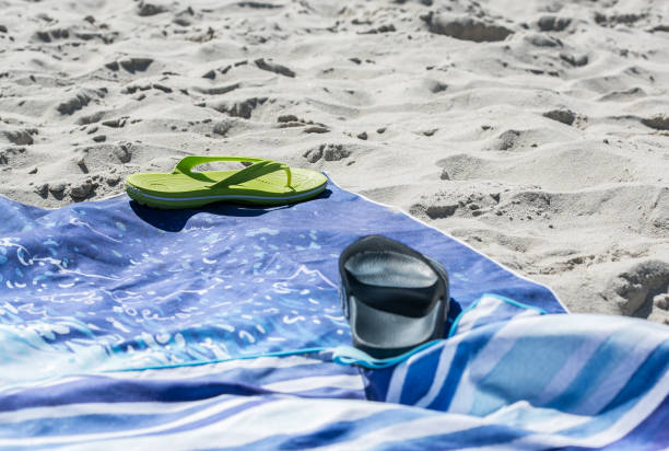 istock Shoes and towels on the beach 2168340222