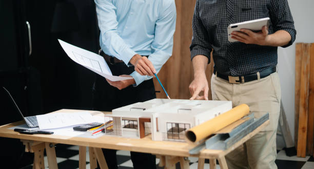 istock Two colleagues discussing data working and tablet, laptop with architectural project at construction site 2168342920