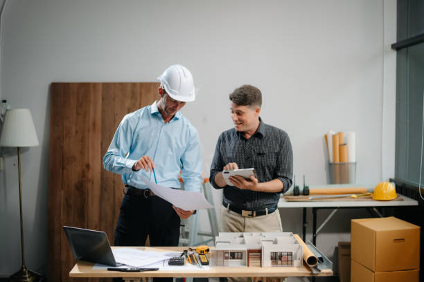 istock Two colleagues discussing data working and tablet, laptop with architectural project at construction site 2168342923