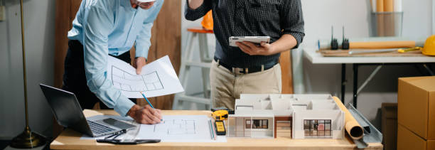 istock Two colleagues discussing data working and tablet, laptop with architectural project at construction site 2168342930