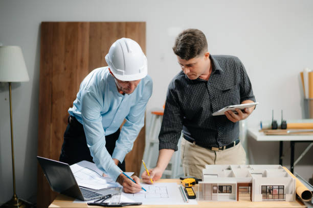 istock Two colleagues discussing data working and tablet, laptop with architectural project at construction site 2168342931