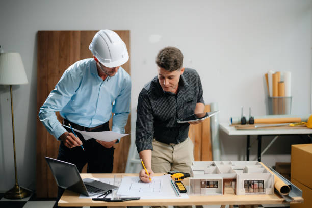 istock Two colleagues discussing data working and tablet, laptop with architectural project at construction site 2168342935