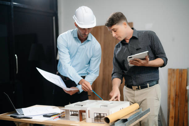 istock Two colleagues discussing data working and tablet, laptop with architectural project at construction site 2168342940