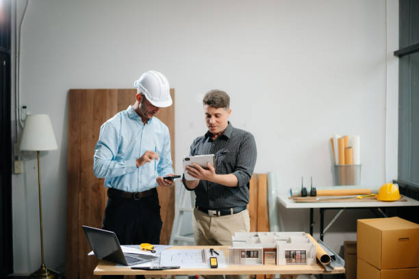 istock Contractor and architect looking at plan, tablet, laptop and talking about working on big project. 2168342948