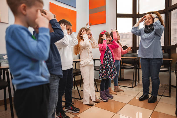 istock Woman teaching a group of elementary students body parts at language school 2168343282