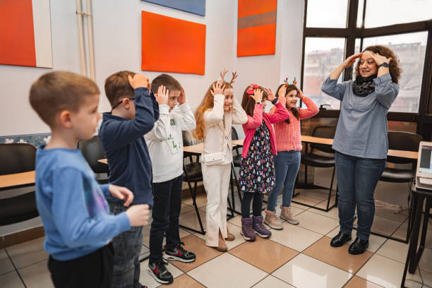 istock Woman teaching a group of elementary students body parts at language school 2168343335