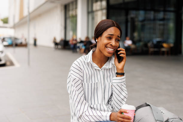 istock Young woman using phone in front of shopping mall 2168346580