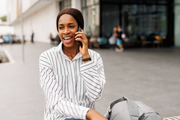 istock Young woman using phone in front of shopping mall 2168346639