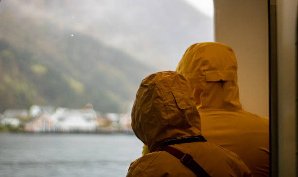 Tourists looking out window on a fjord cruise on Bergen, Norway