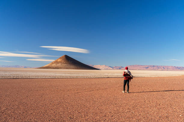 View of a tourist while contemplating the desert landscape of Cono de Arita, Salar de Arizaro, Salta province, Puna, Argentina