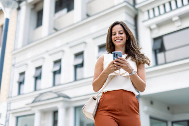 istock Woman in business attire smiling while using phone 2168360869