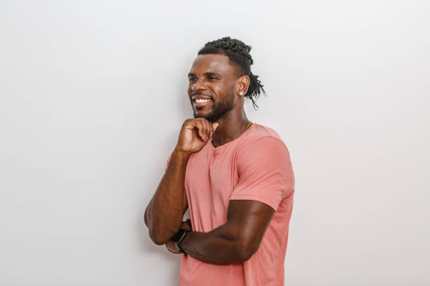 istock Young Man Smiling Joyfully While Leaning Against a Wall in Casual Attire 2168361049