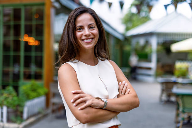 istock Cheerful woman with arms crossed smiling outdoors, confident 2168361559