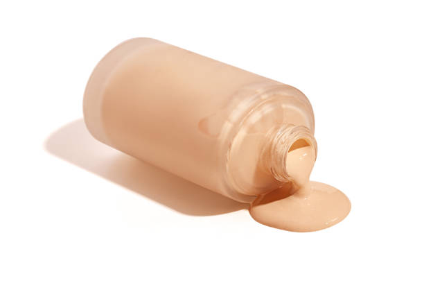 istock Liquid foundation spilled out of bottle isolated on white background 2168364199