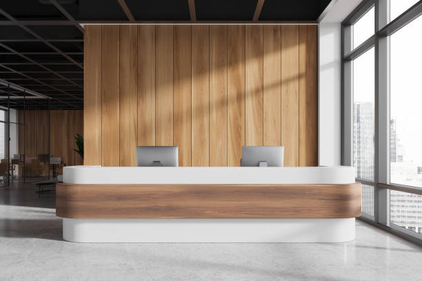 istock Modern office reception desk with computers, wooden panels, and large windows. Minimalist design. Bright natural light. Concept of office interiors. 3D rendering 2168367865