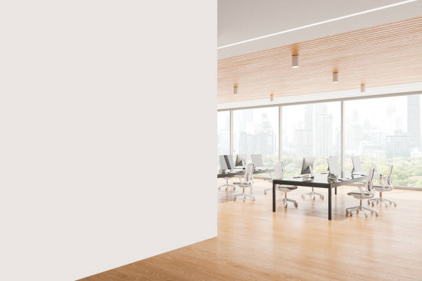 istock Empty white wall on the left and a bright modern office space with desks and chairs on a city view background, office decor concept.  3D Rendering 2168367950