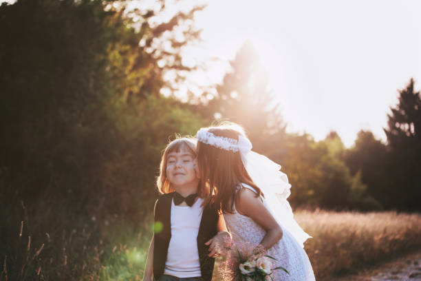 Little groom and bride share a kiss after vows. Newlywed couple.