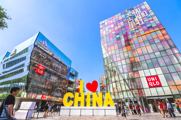 Beijing, China - September 21, 2019. The vibrant I Love CHINA sign stands prominently in the bustling Taikoo Li Sanlitun shopping district in Beijing, China. Framed by the colorful glass facade of the Taikoo Li building and the nearby Adidas and UNIQLO stores, the sign serves as a symbol of national pride amid a lively urban environment.