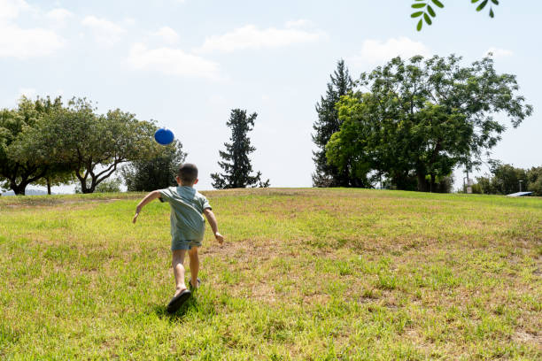 istock Child Running After Frisbee On Sunny Day 2168372641