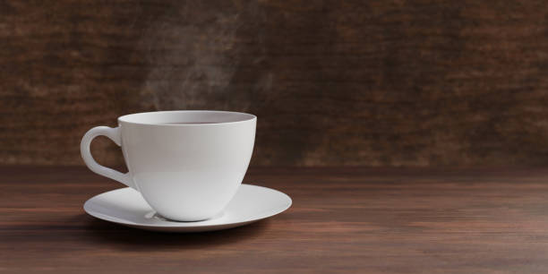 Coffee cup and smoke on dark brown table stock photo