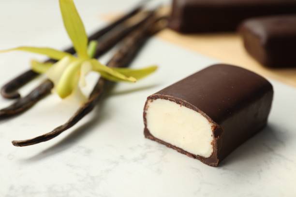 istock Glazed curd cheese bars, vanilla pods and flower on white table, closeup 2168375560