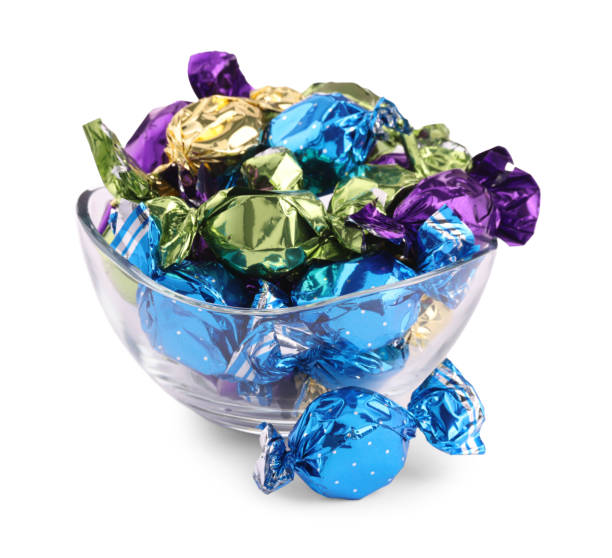 istock Bowl with candies in colorful wrappers isolated on white 2168375752