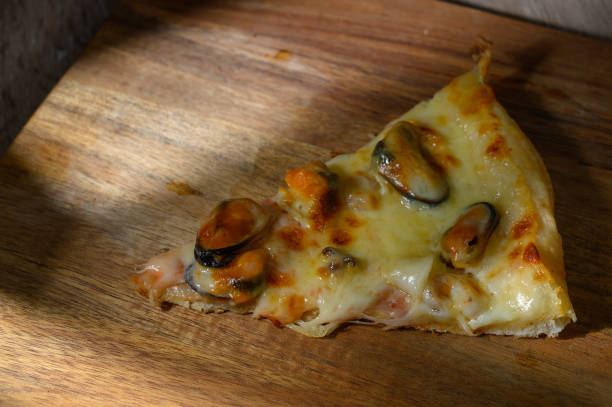 Slice of pizza cheese crust seafood topping sauce.