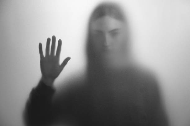 istock Silhouette of ghost behind fabric against light grey background. Black and white effect 2168387944