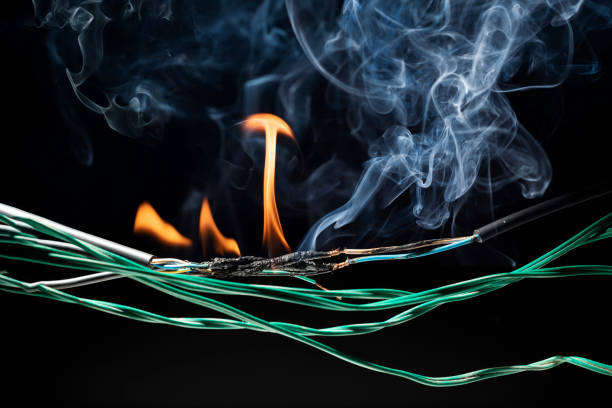 istock Flames from electric shocks Short-circuited cables cause sparks, explosions, excessive power usage, damaged and non-standard equipment.  on a dark black background 2168391475