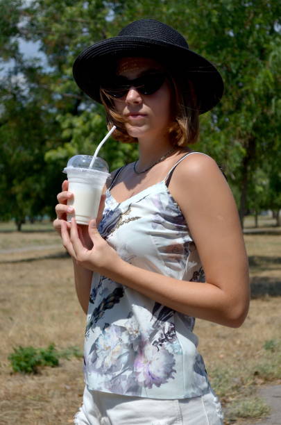 istock Pretty girl with milkshake in a park 2168402227