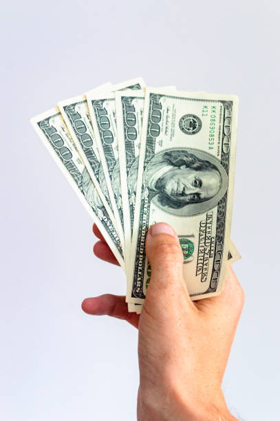 istock 5 one hundred US dollars note in the hand. Bills with Benjamin Franklin's portrait. 2168404331