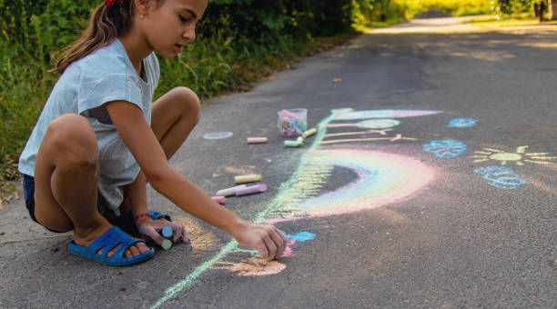 a child draws with chalk on the asphalt. beautiful picture
