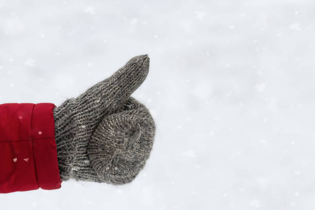 istock A warm mitten on a snowy background. Winter theme. 2168405296
