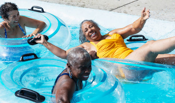 Three senior women at water park floating on lazy river