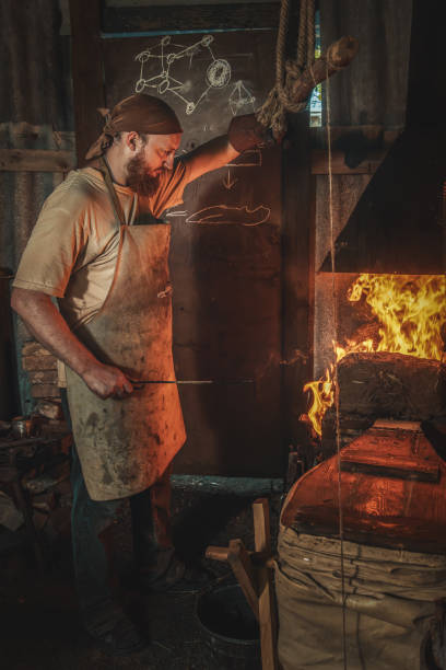 istock Blacksmith heats a metal part in a fire before forging it in an old village forge. Traditional crafts 2168413528