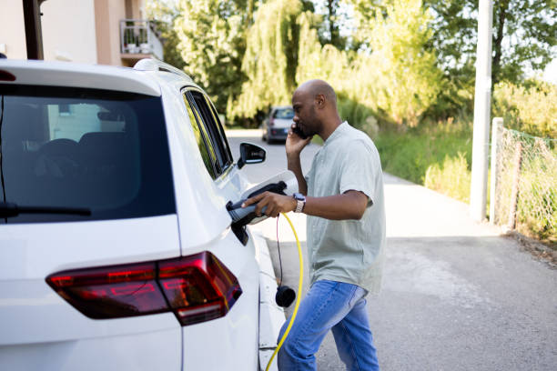 istock Latin man talking on mobile phone and powering up his EV 2168413689