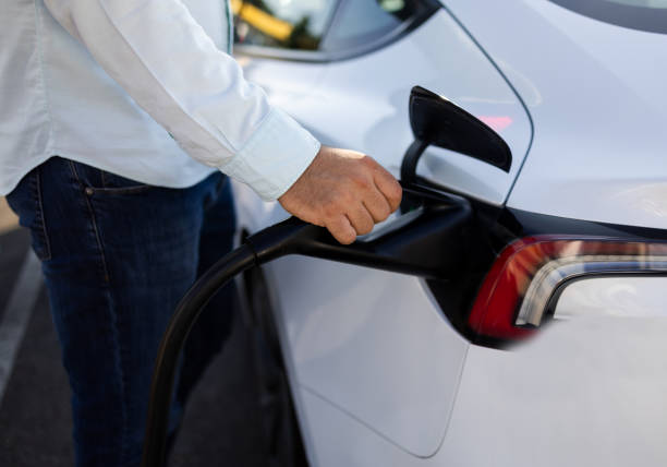 istock Unrecognizable man plugs in his electric car 2168413847