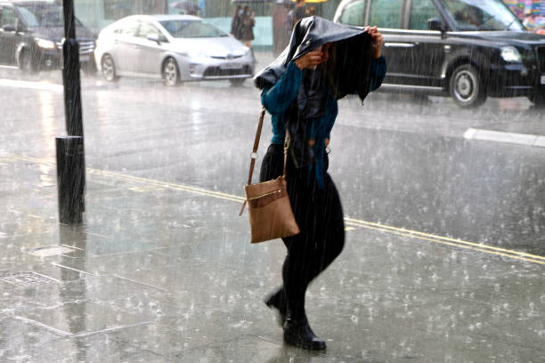 femme marchant sous une pluie battante sur oxford street, londres. - pluie diluvienne photos et images de collection