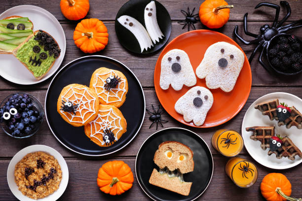 istock Spooky Halloween breakfast table scene over a dark wood background. Top down view. Assorted pancakes, toast, oatmeal and fruit. 2168430410