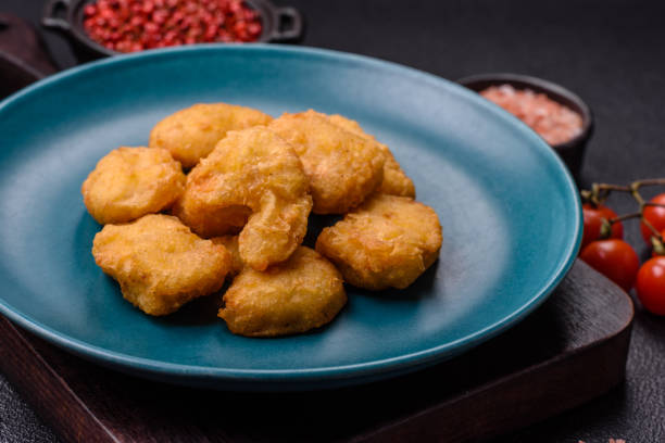 istock Delicious fresh crispy chicken nuggets on a dark concrete background 2168432162