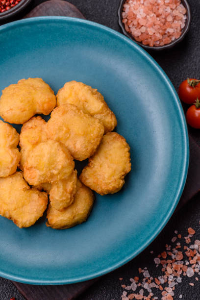 istock Delicious fresh crispy chicken nuggets on a dark concrete background 2168433004